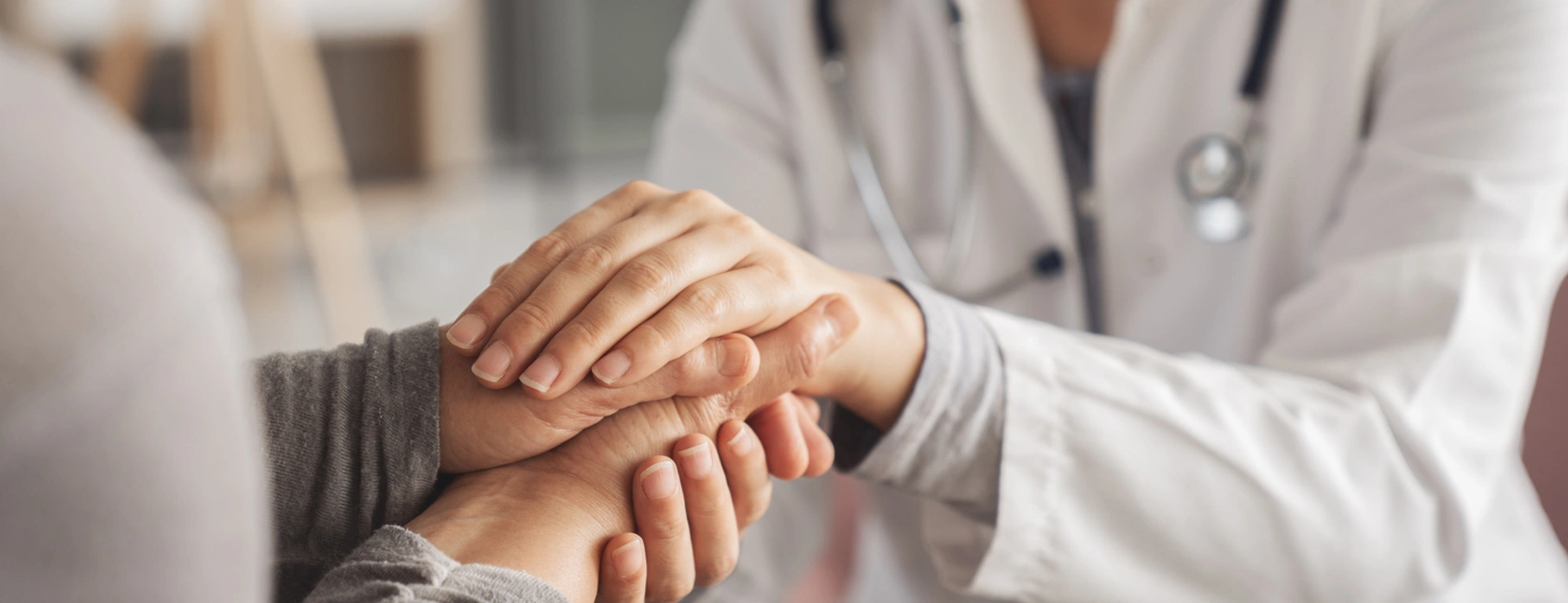 Doctor holding a patient's hand in support