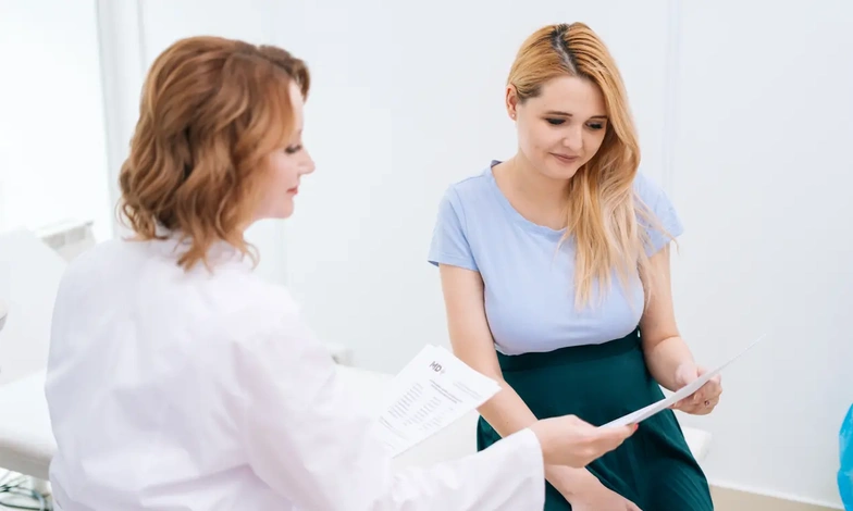 Healthcare professional and patient reviewing documents during a fertility consultation - sv.